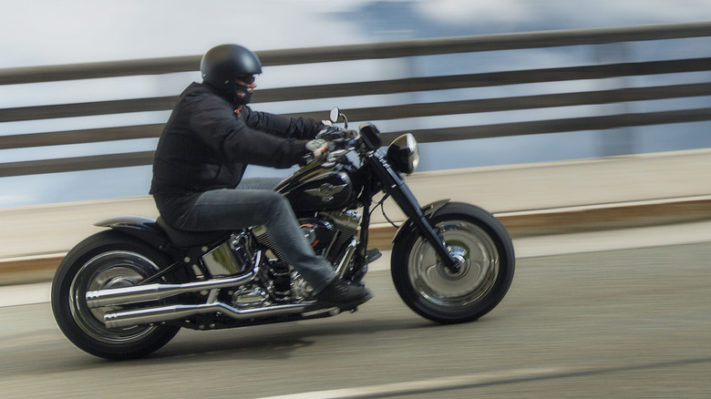 Eine Person, die mit ihrem Harley-Davidson eine Straße hinunterfährt.